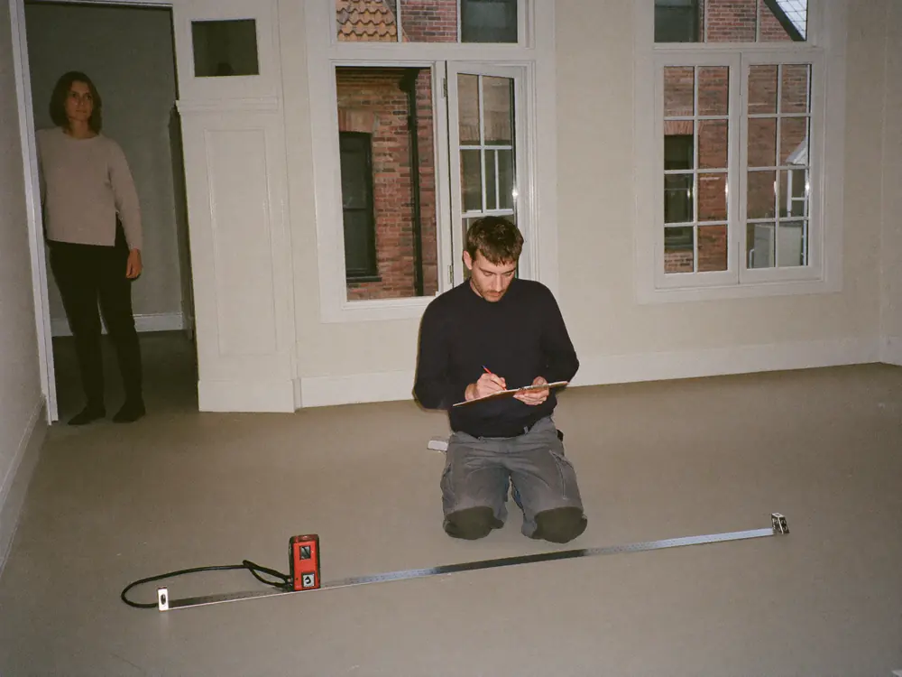Vloerlegger meet het vocht in de dekvloer tijdens het inmeten